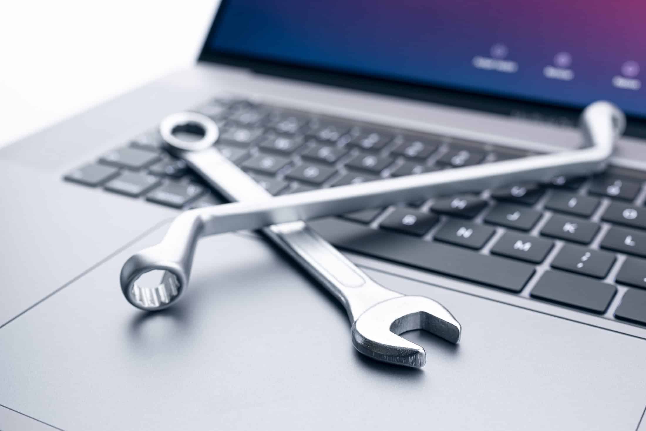 Tools on a laptop to illustrate the need for ongoing website maintenance.